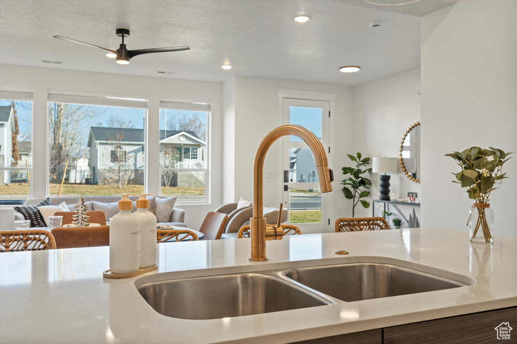 Kitchen featuring a textured ceiling, sink, ceiling fan, and a healthy amount of sunlight