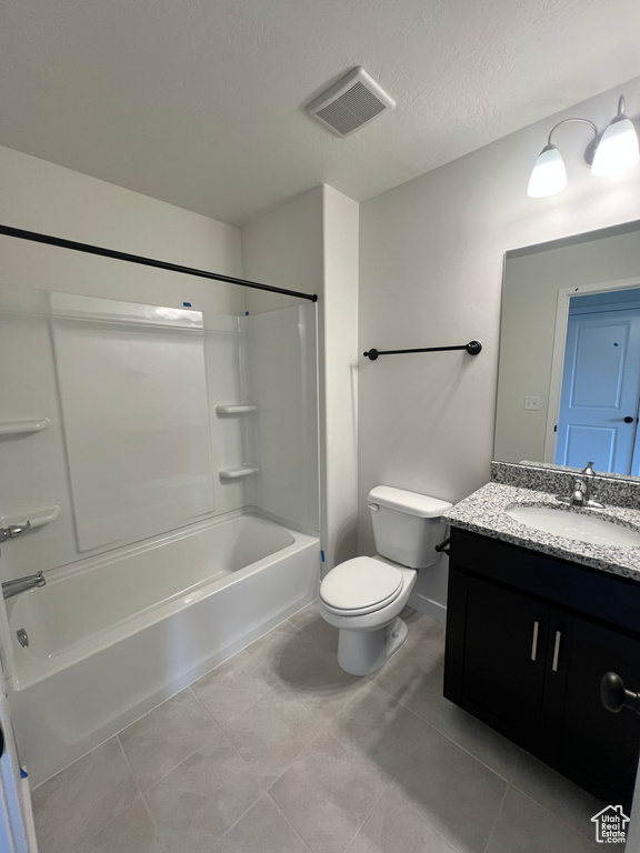 Full bathroom featuring toilet, tile flooring, vanity with extensive cabinet space, and bathing tub / shower combination