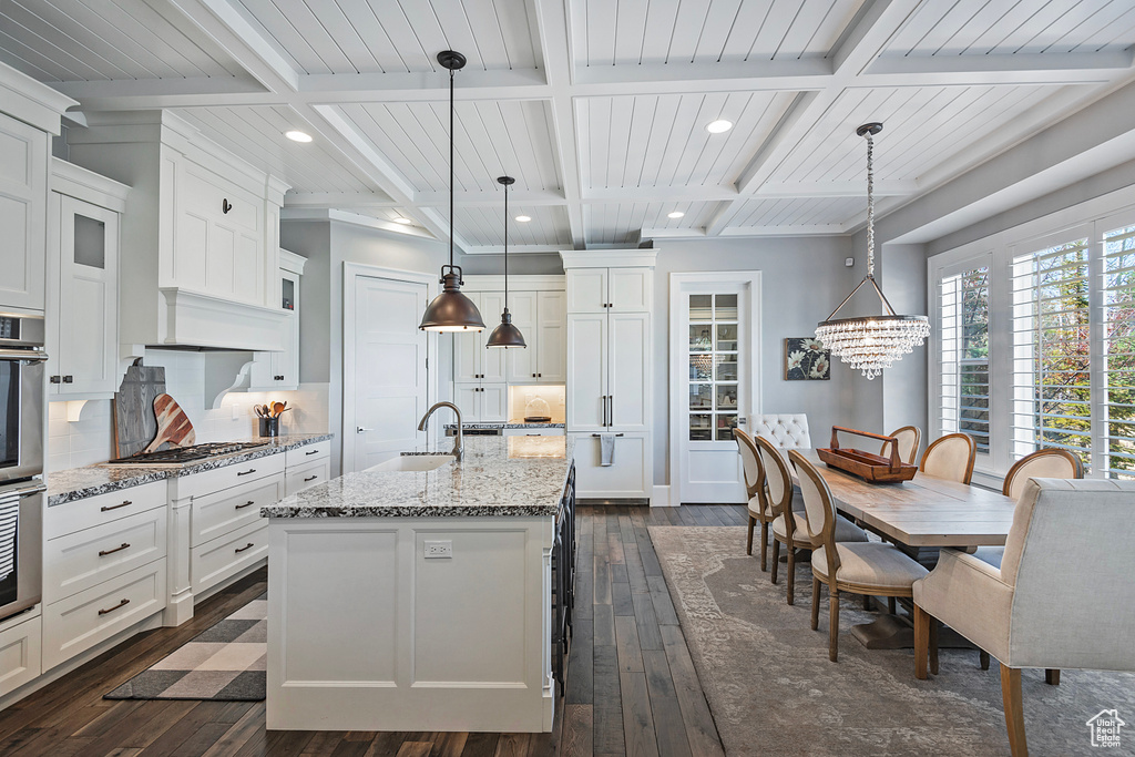 Kitchen with hanging light fixtures and coffered ceiling