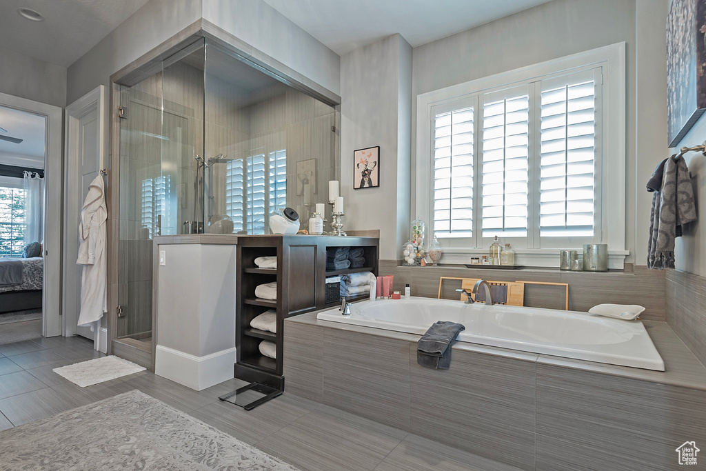Bathroom featuring tile floors, separate shower and tub, and oversized vanity