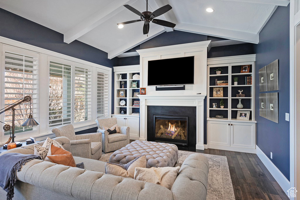 Living room featuring lofted ceiling with beams, built in features, ceiling fan, and dark hardwood / wood-style floors