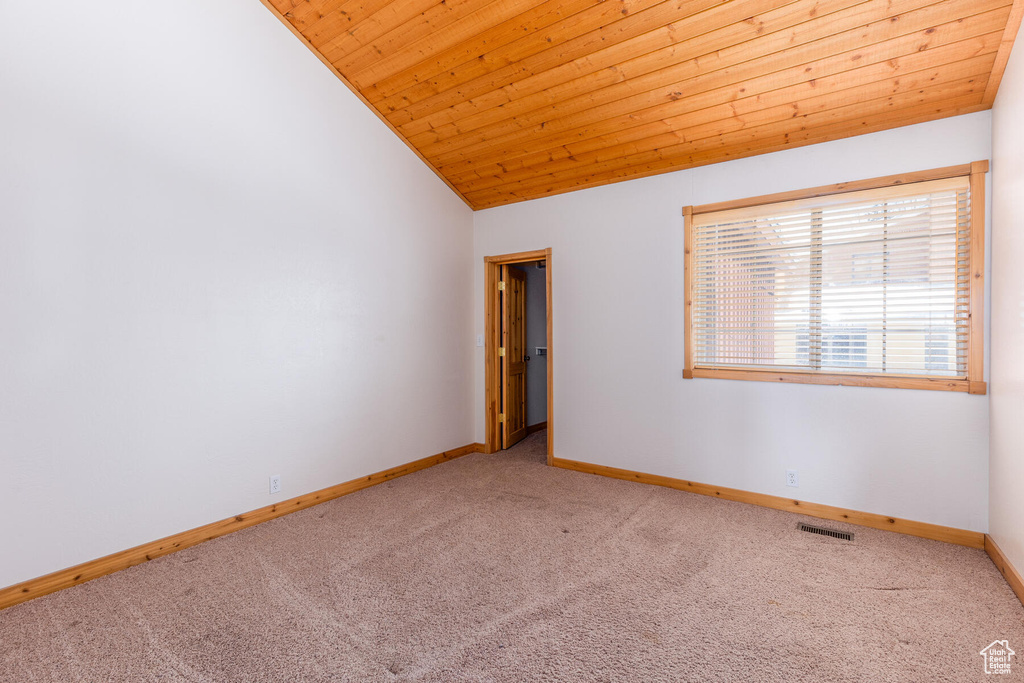 Unfurnished room featuring wooden ceiling, vaulted ceiling, and light colored carpet