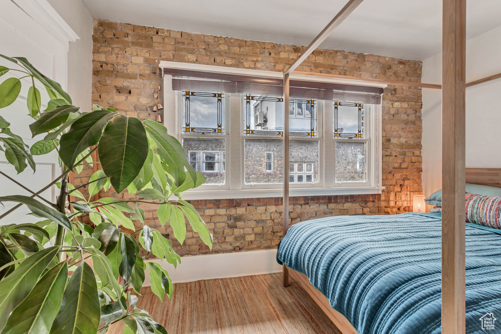 Bedroom with multiple windows and brick wall