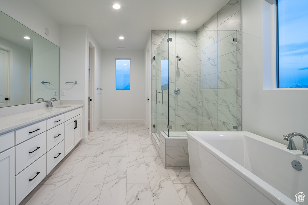 Bathroom with tile floors, large vanity, and independent shower and bath
