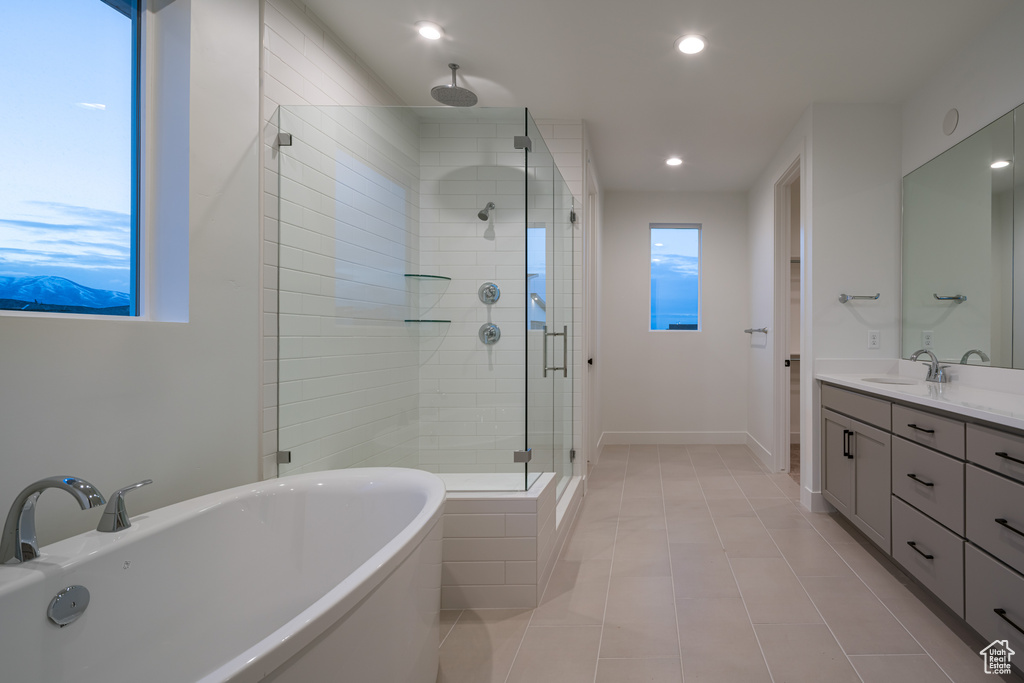 Bathroom featuring tile flooring, vanity, and plus walk in shower