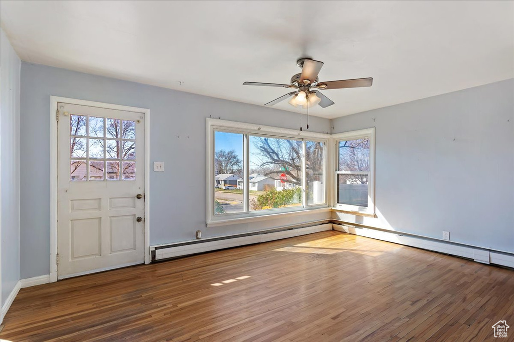 Entryway featuring ceiling fan, dark wood-type flooring, and a baseboard heating unit