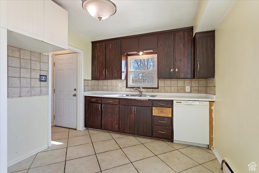 Kitchen with backsplash, dark brown cabinets, light tile floors, and dishwasher