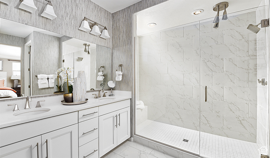 Bathroom featuring dual bowl vanity, walk in shower, and tile flooring