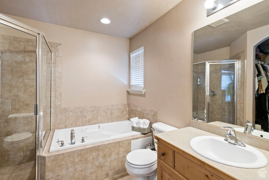 Full bathroom with plus walk in shower, toilet, and vanity with extensive cabinet space