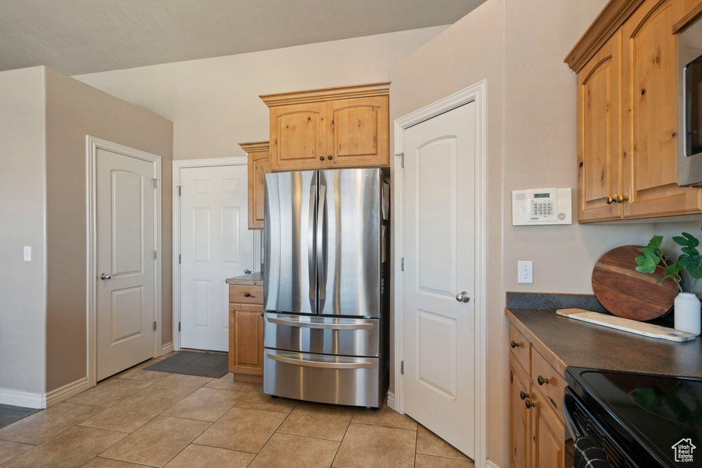 Kitchen featuring stainless steel refrigerator and light tile floors