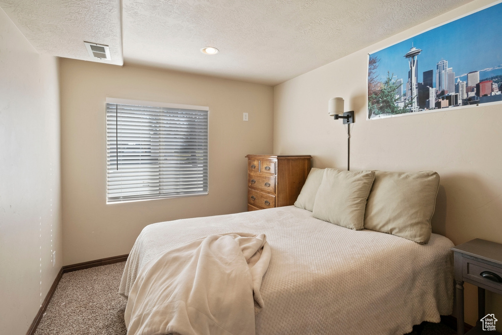 Bedroom featuring a textured ceiling and carpet