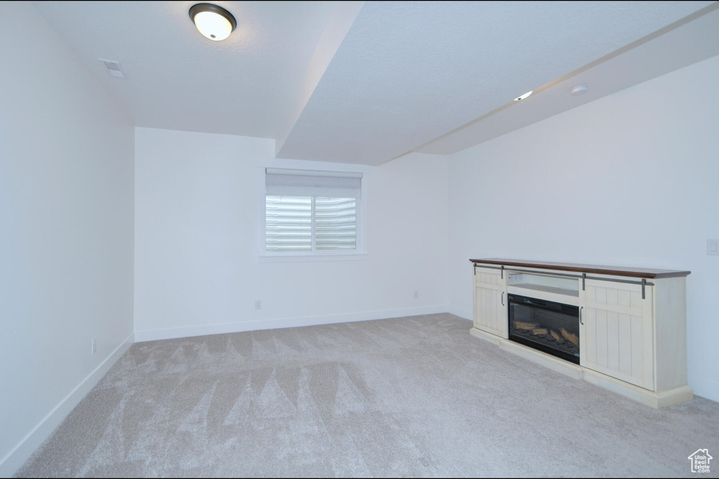Unfurnished living room featuring light colored carpet