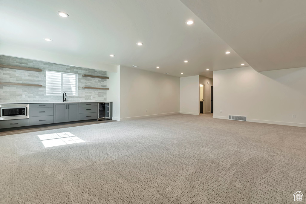 Unfurnished living room with light carpet and wine cooler