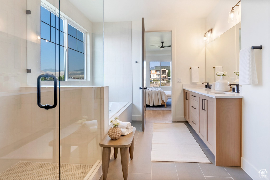 Bathroom with vanity, tile patterned flooring, ceiling fan, and a healthy amount of sunlight