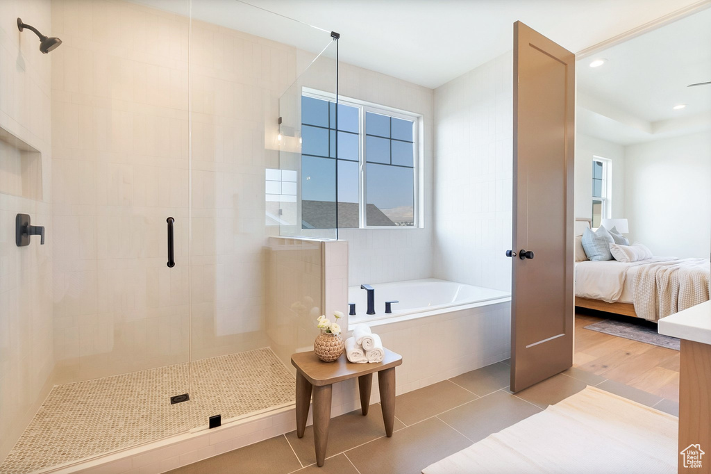 Bathroom featuring plus walk in shower, tile patterned flooring, and a healthy amount of sunlight