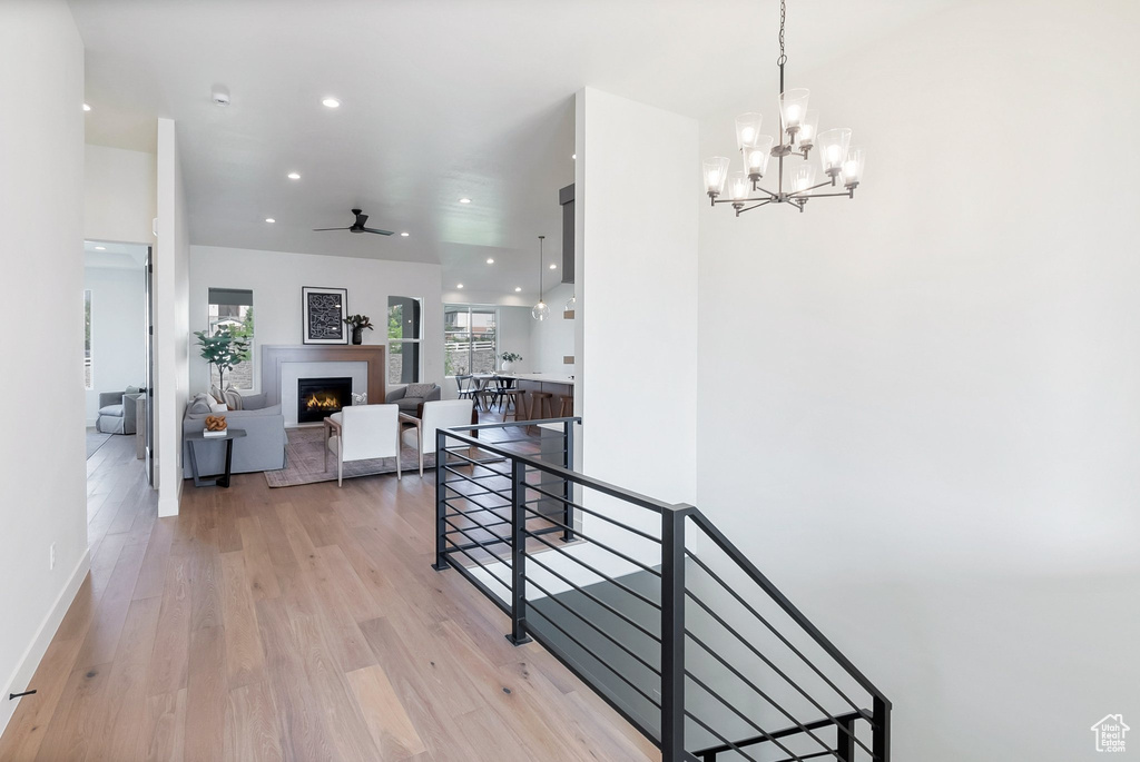 Corridor featuring light hardwood / wood-style floors and a notable chandelier