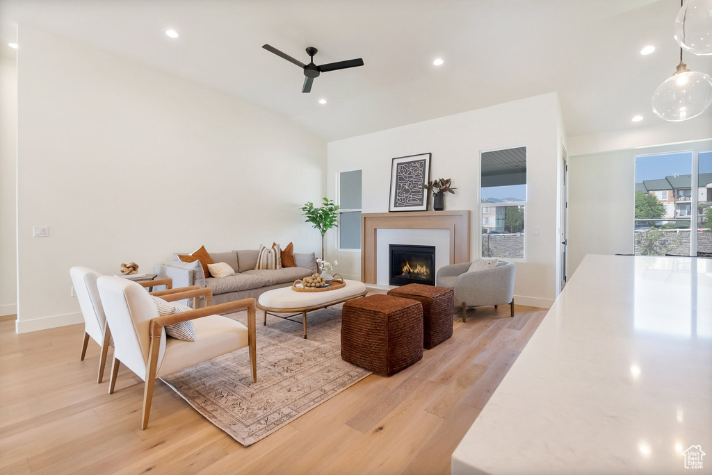 Living room featuring lofted ceiling, light wood-type flooring, and ceiling fan