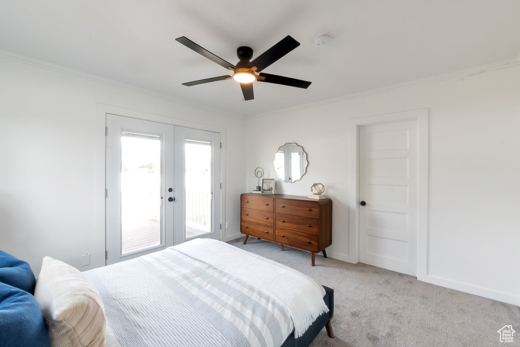 Bedroom featuring light carpet, french doors, ornamental molding, ceiling fan, and access to exterior