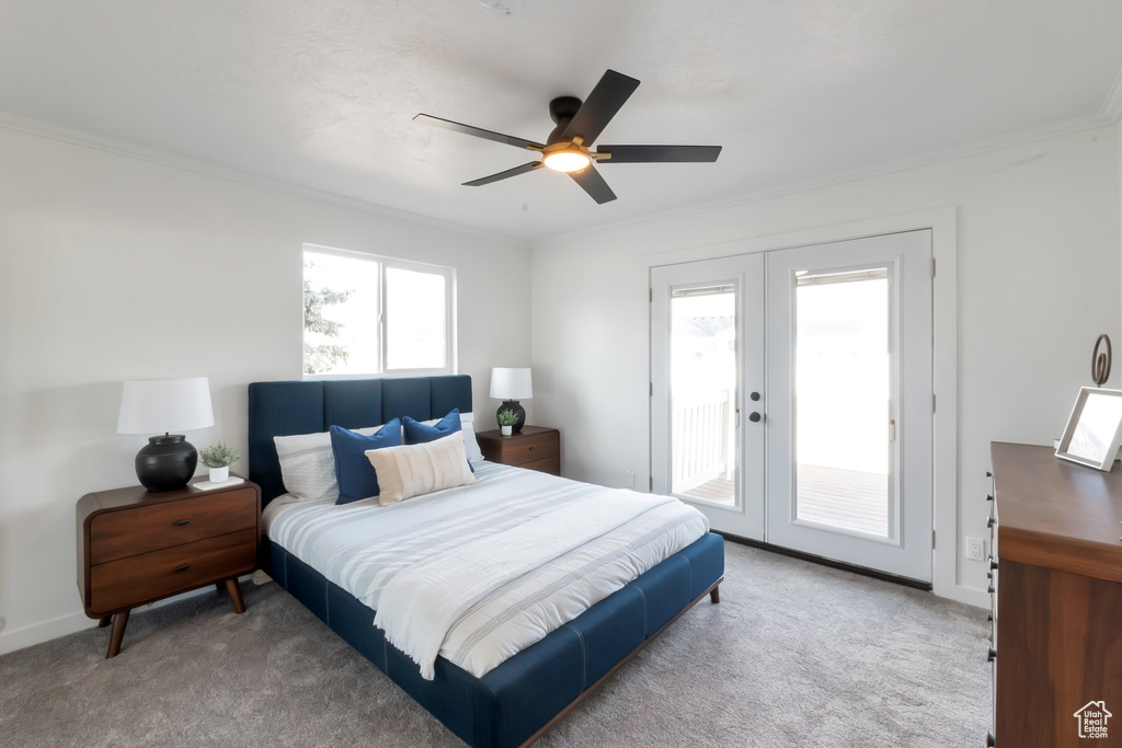 Bedroom featuring crown molding, light carpet, french doors, and access to outside