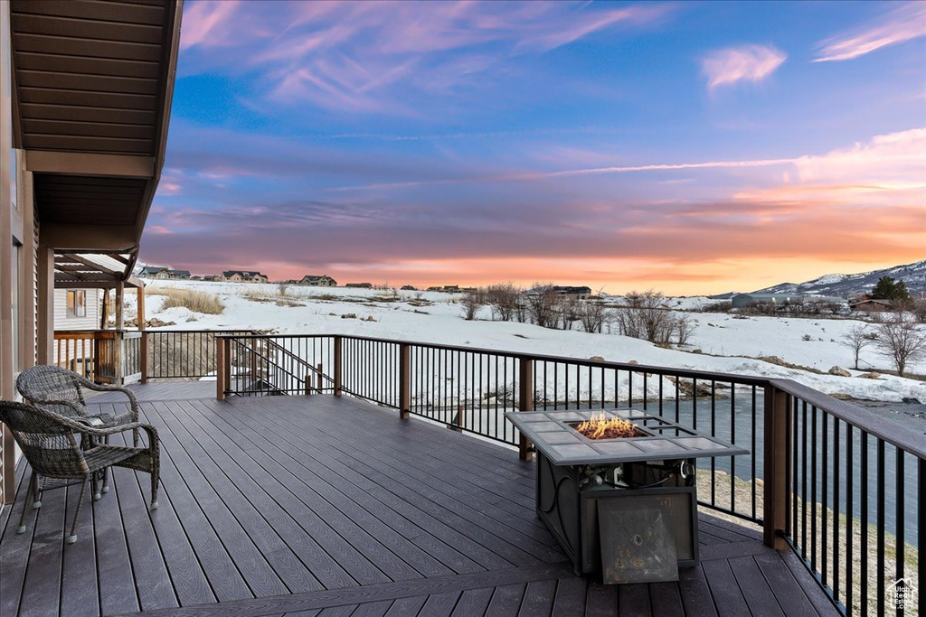 Snow covered deck featuring a fire pit