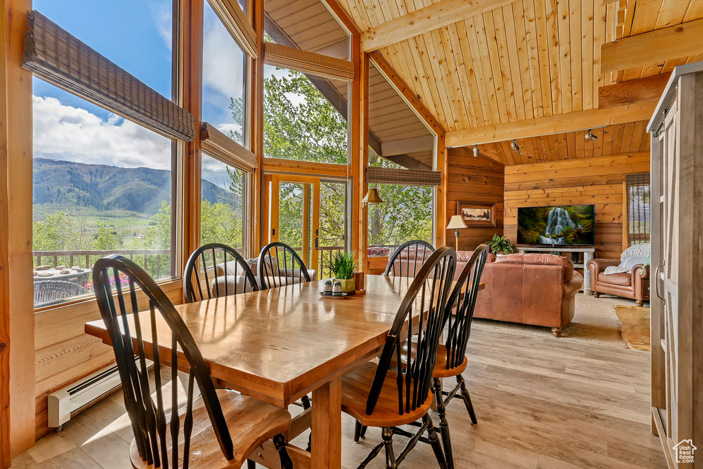 Dining space featuring a mountain view, wooden ceiling, a healthy amount of sunlight, and light wood-type flooring