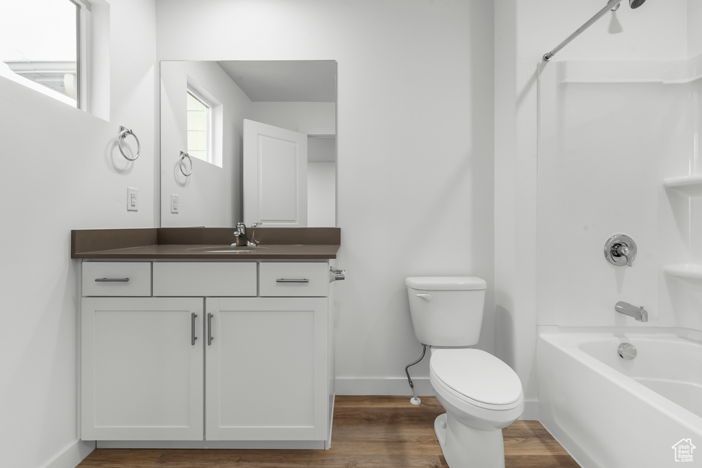 Full bathroom featuring bathtub / shower combination, wood-type flooring, vanity, and toilet