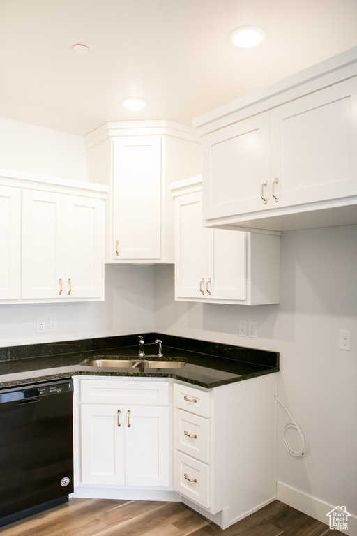 Kitchen with white cabinets, light hardwood / wood-style flooring, sink, and black dishwasher