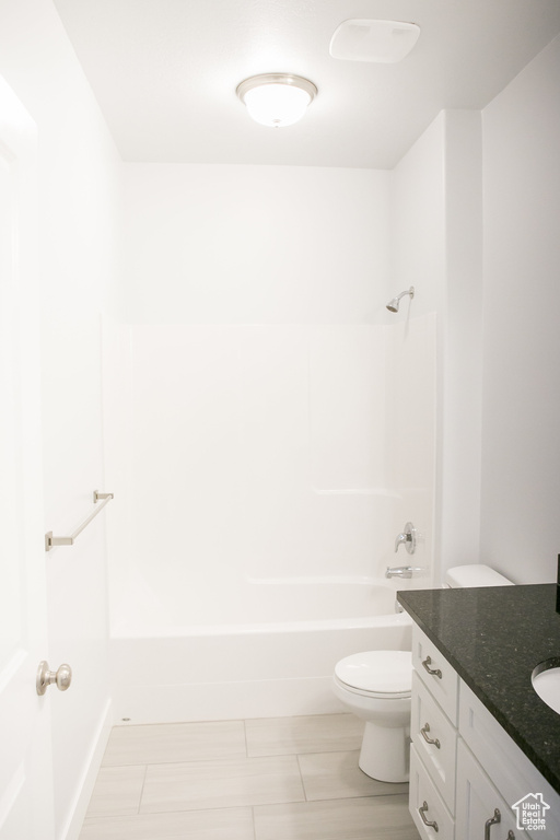 Full bathroom featuring vanity, shower / tub combination, toilet, and tile floors