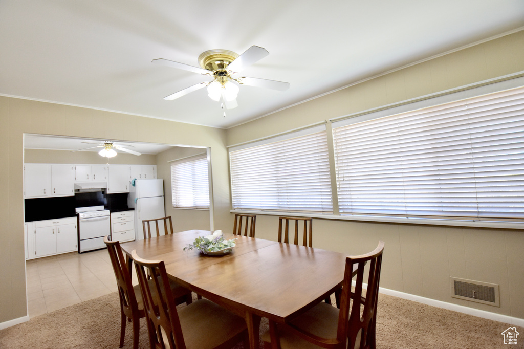 Dining room with light colored carpet and ceiling fan