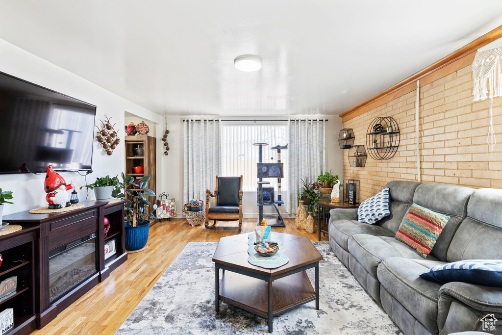 Living room featuring light hardwood / wood-style flooring and brick wall