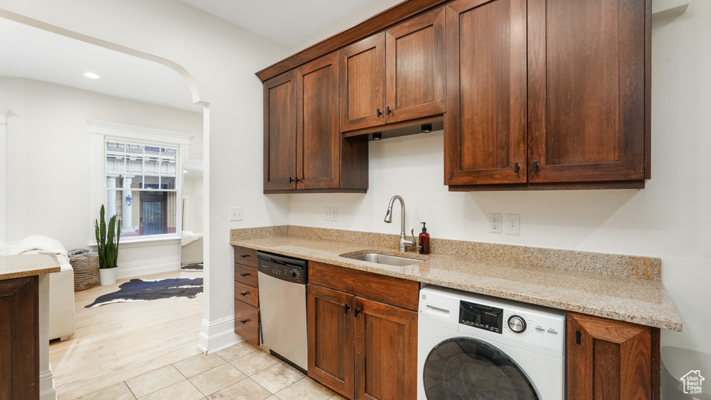 Kitchen featuring washer / clothes dryer, sink, light tile flooring, light stone countertops, and dishwasher
