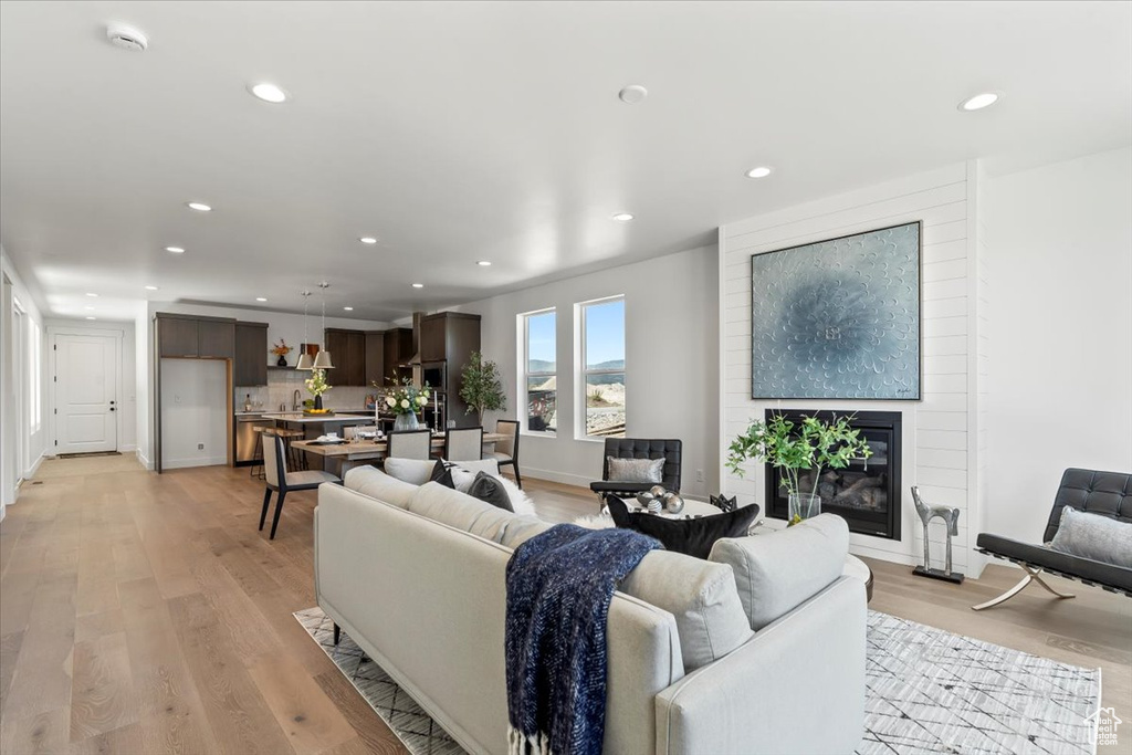 Living room featuring brick wall and light hardwood / wood-style flooring