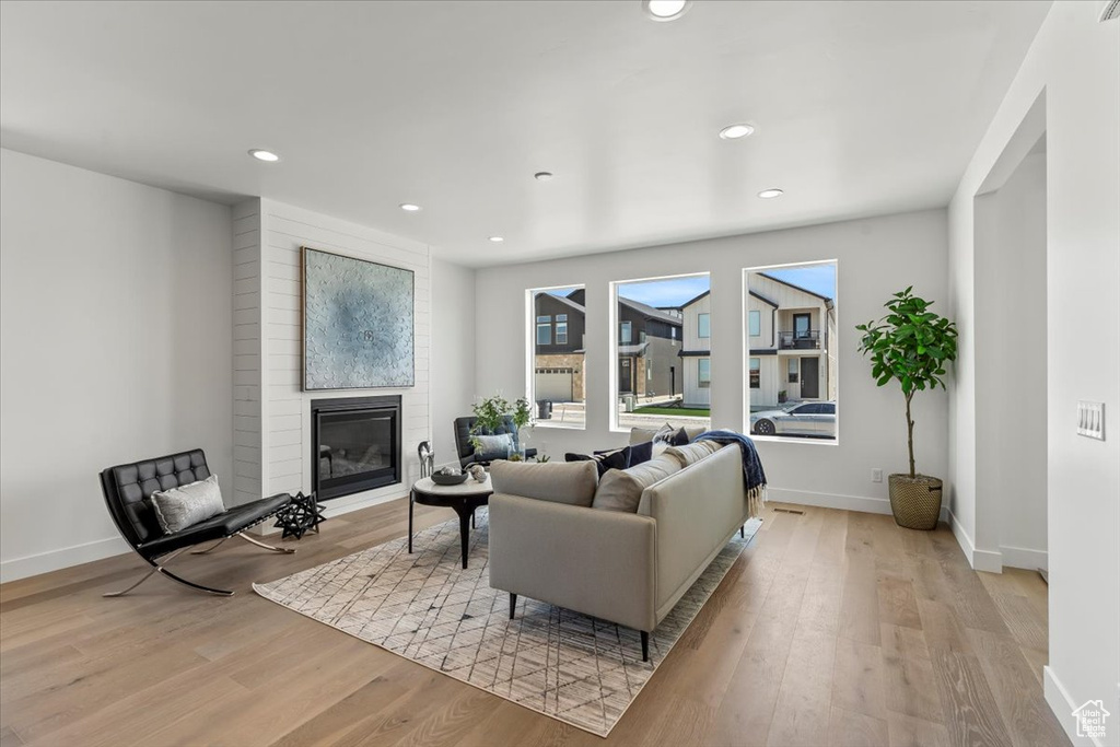 Living room with a large fireplace and light wood-type flooring