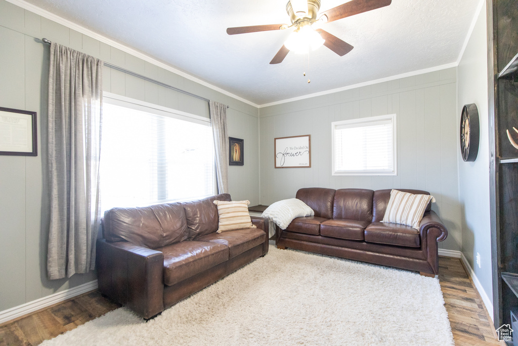 Living room featuring crown molding, hardwood / wood-style floors, and ceiling fan