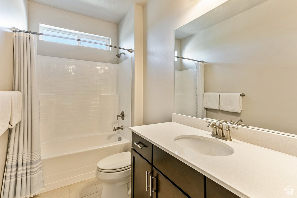 Full bathroom featuring tile flooring, large vanity, toilet, and shower / tub combo with curtain