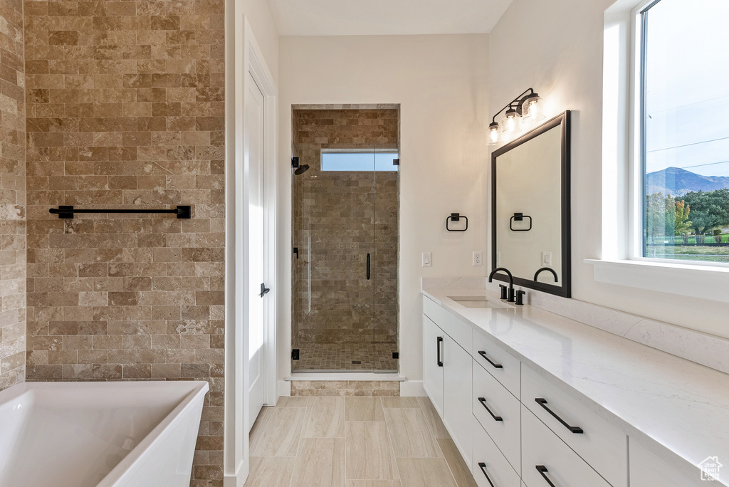 Bathroom with tile flooring, separate shower and tub, a mountain view, and large vanity