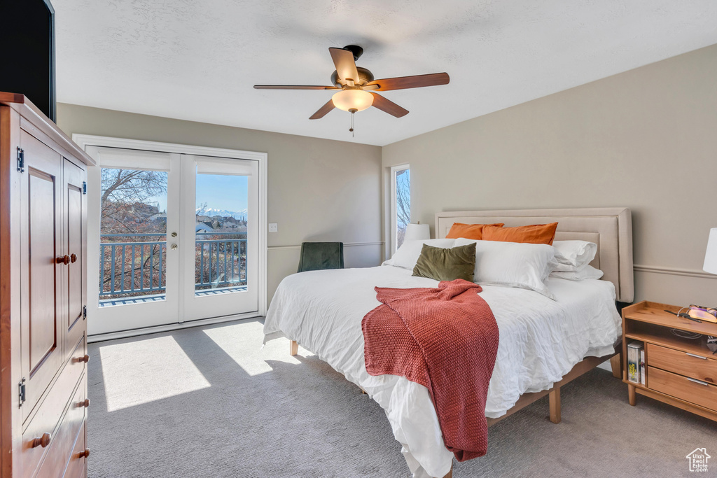 Carpeted bedroom featuring ceiling fan, access to exterior, and french doors