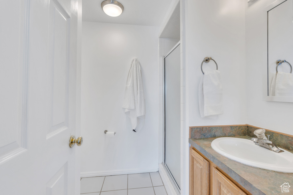 Bathroom featuring vanity, walk in shower, and tile floors