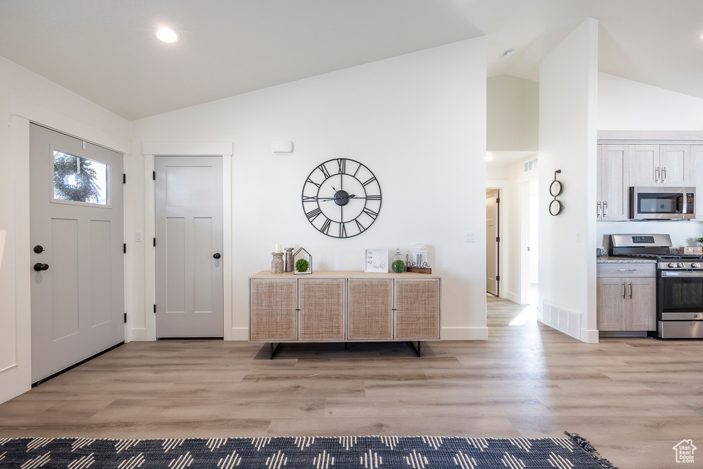 Entrance foyer featuring vaulted ceiling and light hardwood / wood-style flooring