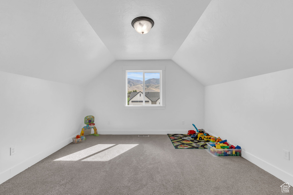 Playroom with vaulted ceiling and carpet flooring