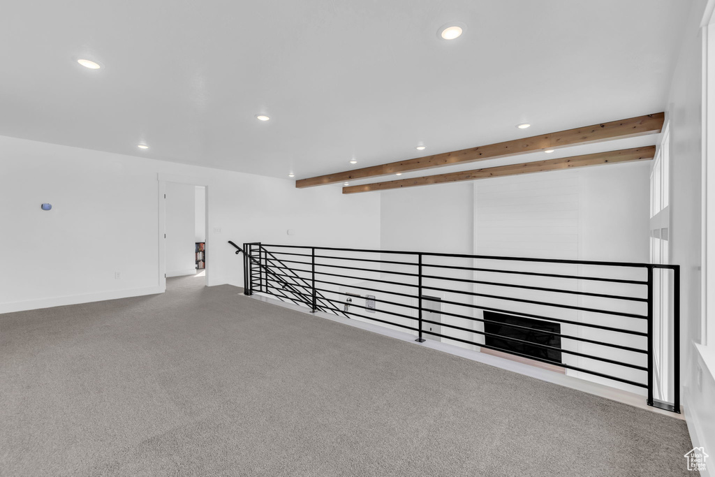 Interior space featuring carpet flooring and beam ceiling