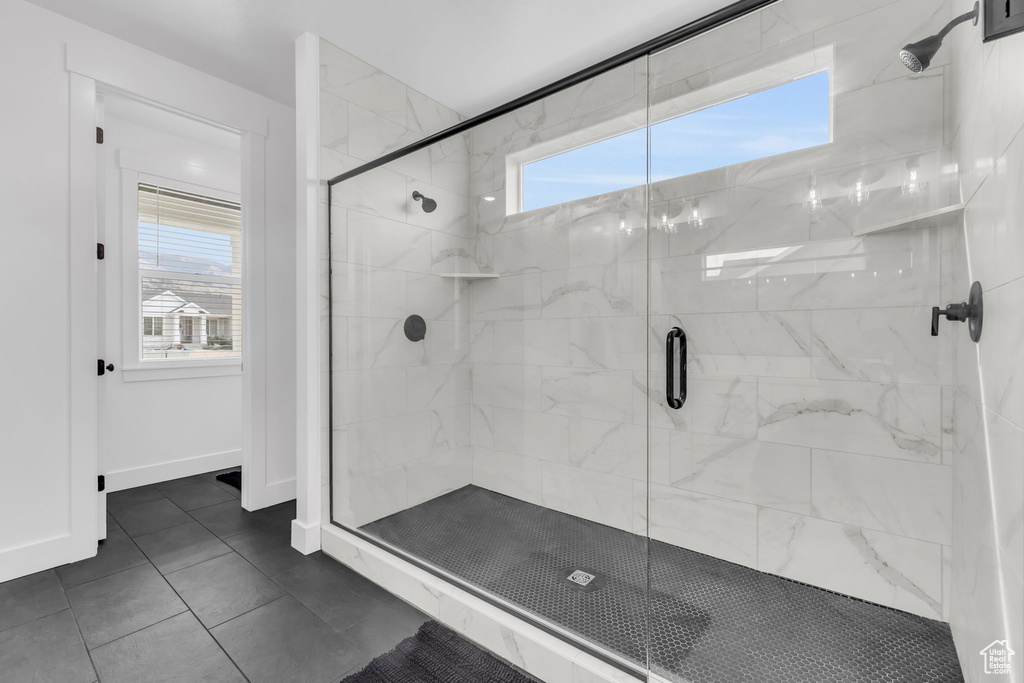 Bathroom featuring tile flooring and a shower with door