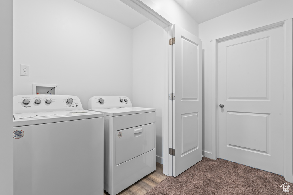 Laundry area with washing machine and dryer, dark carpet, and washer hookup