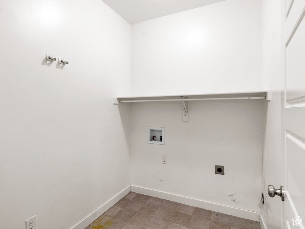 Washroom featuring electric dryer hookup, washer hookup, and light tile floors