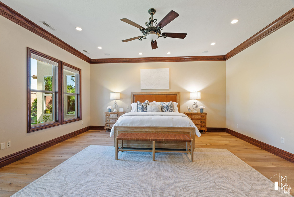 Bedroom featuring light hardwood / wood-style flooring, crown molding, and ceiling fan