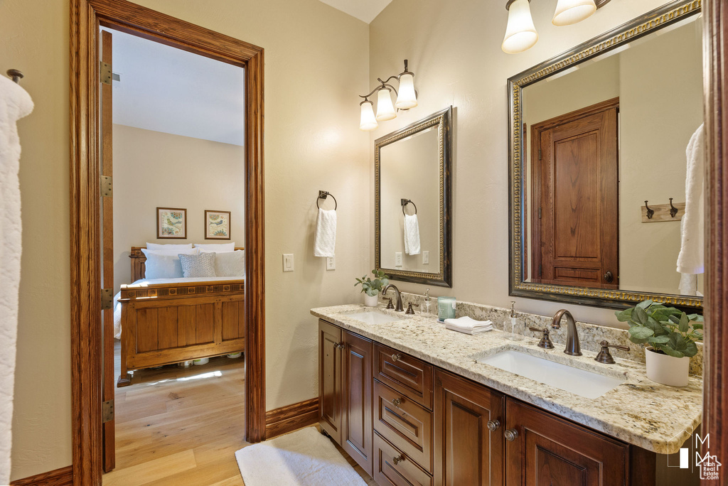 Bathroom with double vanity and hardwood / wood-style flooring