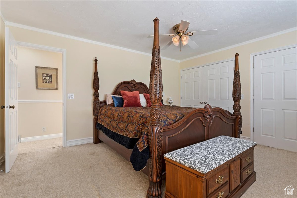 Bedroom featuring a closet, ceiling fan, light carpet, and crown molding