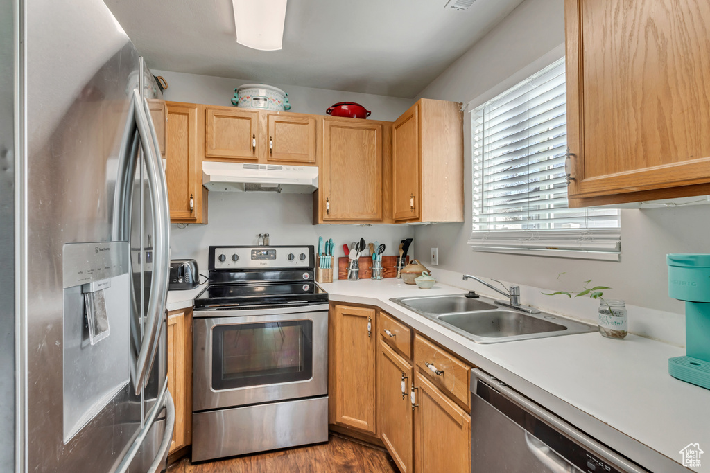 Kitchen featuring appliances with stainless steel finishes, sink, light brown cabinets, and hardwood / wood-style flooring