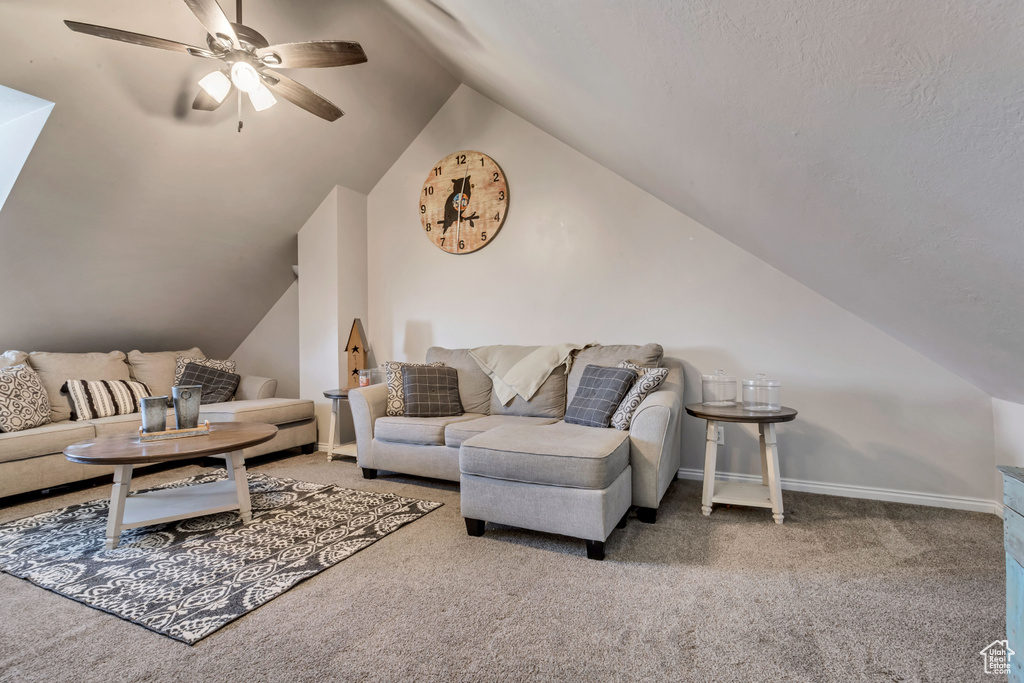 Living room with vaulted ceiling, carpet floors, and ceiling fan