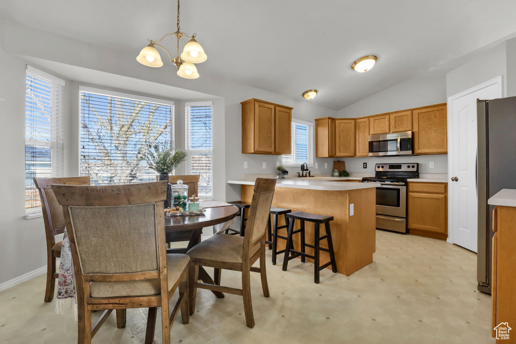 Kitchen featuring a notable chandelier, a healthy amount of sunlight, stainless steel appliances, and pendant lighting